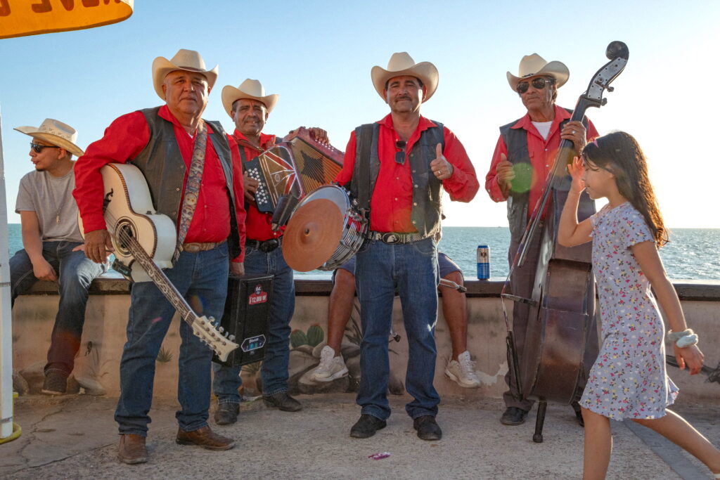 Group of musicians in cowboy hats and red shirts