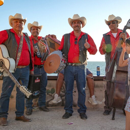 Group of musicians in cowboy hats and red shirts