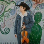 Young man in front of a Chicano-themed mural