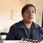 Young man talking into audio recorder