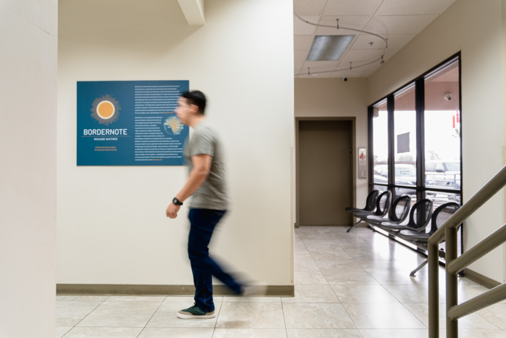 Man walks past sign introducing Bordernote exhibit